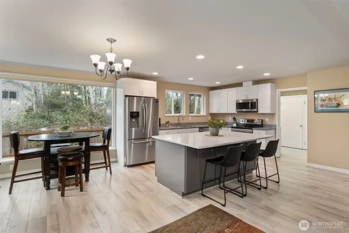 The great room flows seamlessly into this fully-updated kitchen, anchored by an enormous island, with cabinetry on two full sides for tons of storage, and topped with a quartz slab for ample work space.