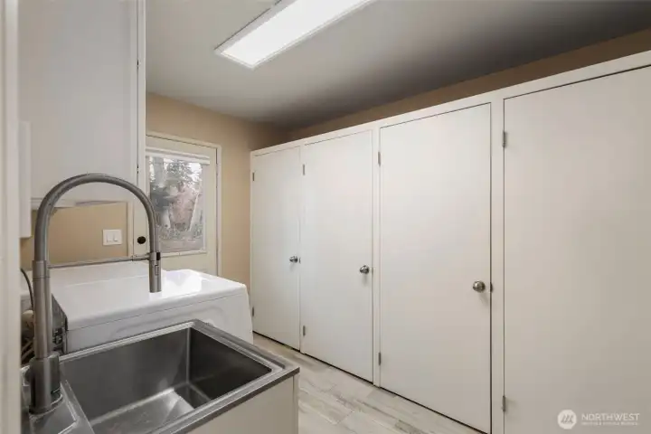 the spacious laundry room features an entire wall of pantry and storage closets!