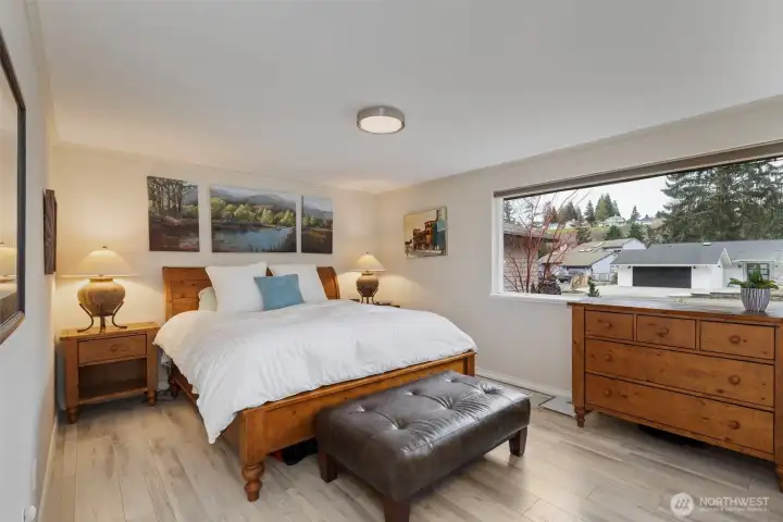 The spacious main floor primary suite is tucked at the end of a hallway for utmost privacy.