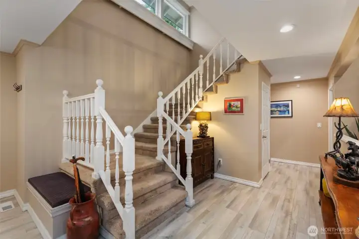 From the great room, follow the stairway to the upper floor, fully lit by large windows above.