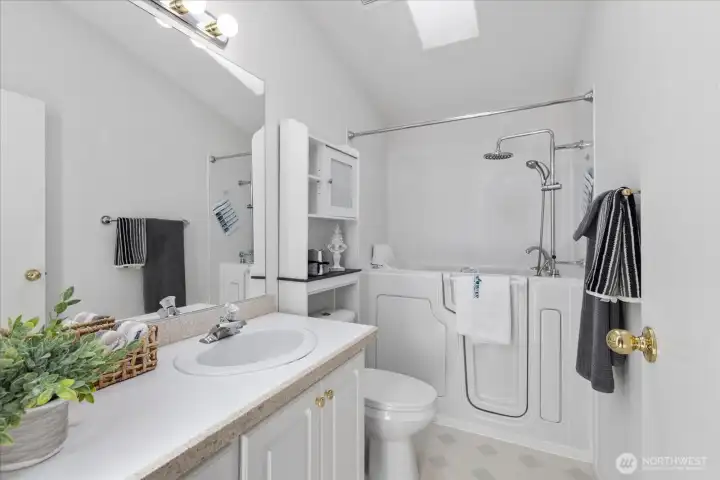 Guest bathroom features a convenient walk-in tub with a built-in shower and jetted system for added comfort.