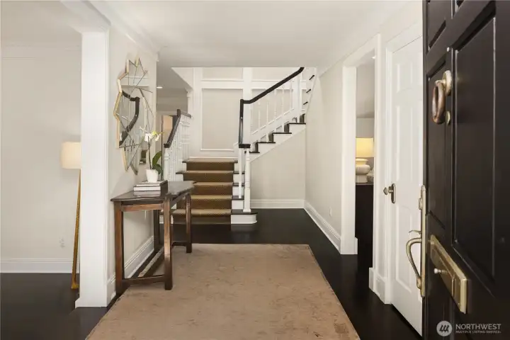 An elegant foyer sets the tone with soaring ceilings, abundadnt natural light, ebony hardwoods classic dental moulding at the ceiling (throughout the home!) and a graceful staircase. An elegant foyer sets the tone with soaring ceilings, abundadnt natural light, ebony hardwoods classic dental moulding at the ceiling (throughout the home!) and a graceful staircase.