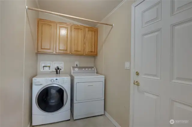 utility room with laundry and door to back yard