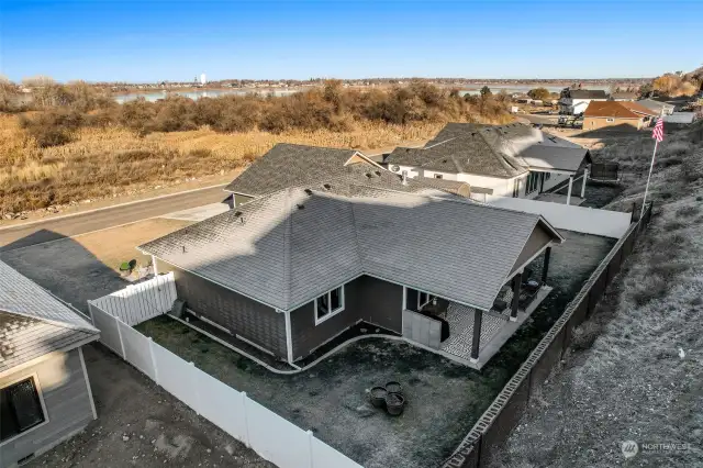 Arial of back side of home showing fully fenced and retaining wall