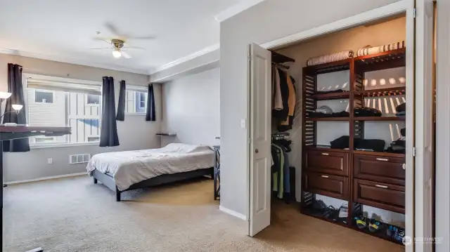 Generous sized walk-in closet with convenient organizer and bi-fold doors.