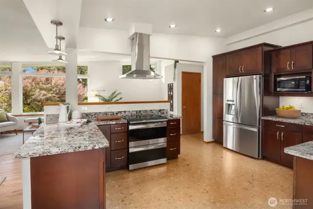 Re-imagined kitchen offers granite counters, cork floors, and stainless appliances.