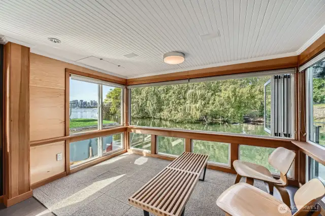 The Euro-style wall of windows fully opens to the right, inviting in the serene sights and sounds of the lake—offering a peaceful, private retreat right from your living room.