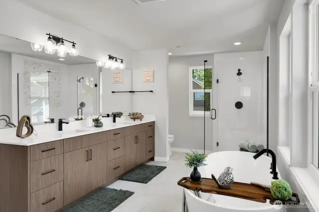 The spa-inspired primary bath boasts a large tiled shower, a deep soaking tub, and a dual vanity with tons of storage.