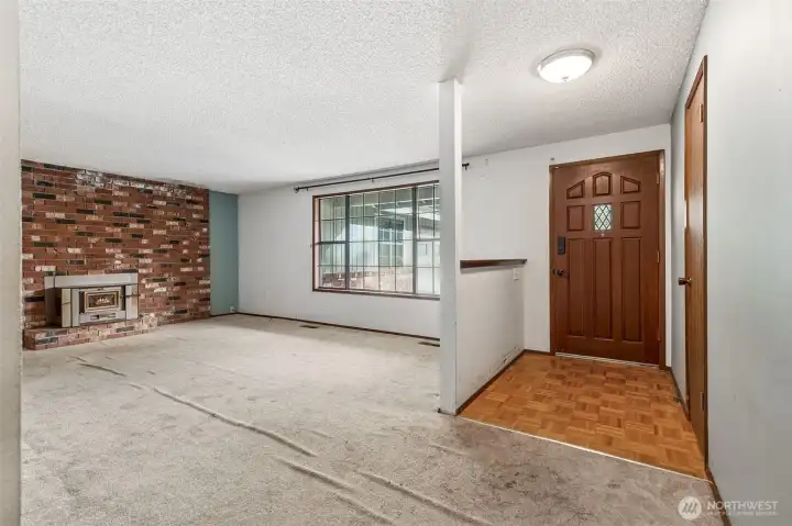 As you enter the home, you will find a parquet flooring entry with coat closet leading into a huge living room with natural floor-to-ceiling fireplace with electric insert.
