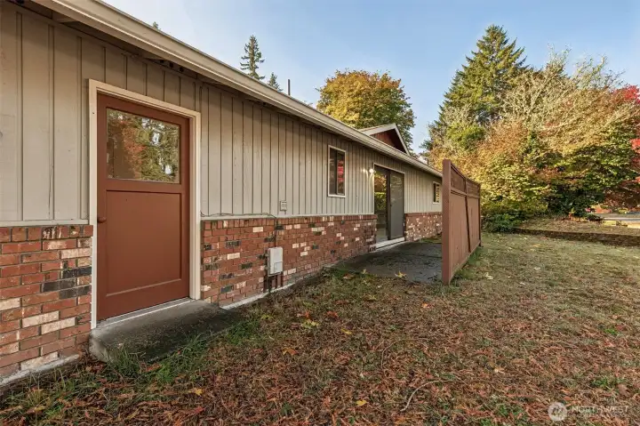 Side yard, patio with fence and garage man door.