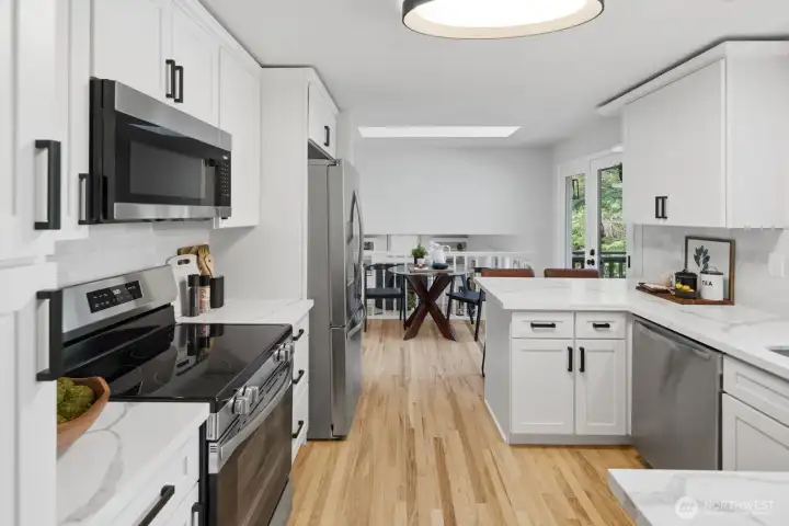 Kitchen showcases gorgeous new cabinets, new quartz counters, new backsplash, new SS appliances, new lighting, new sink, and new fixtures.