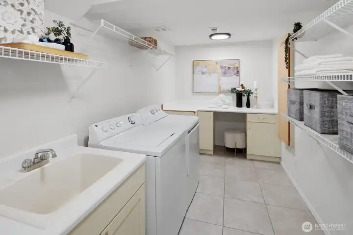 Basement level - updated dream laundry room with washer, dryer, folding table, cabinets, shelving, and laundry sink.