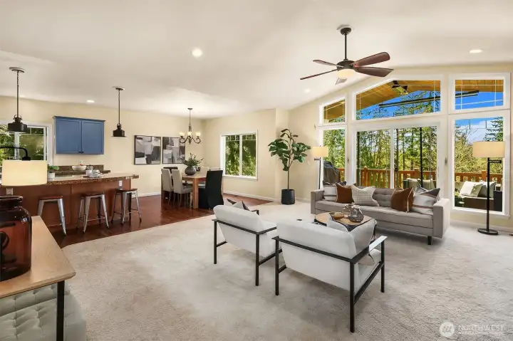 Open living area with vaulted ceilings and floor to ceiling windows.
