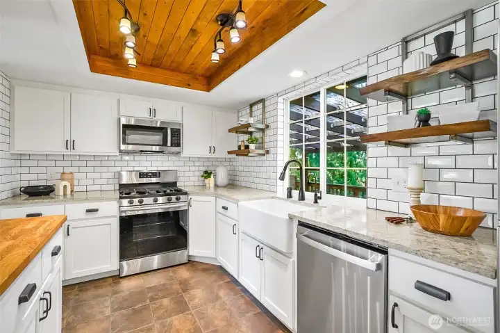 Beautiful, updated kitchen with stainless steel appliances, quartz counters and tile flooring.