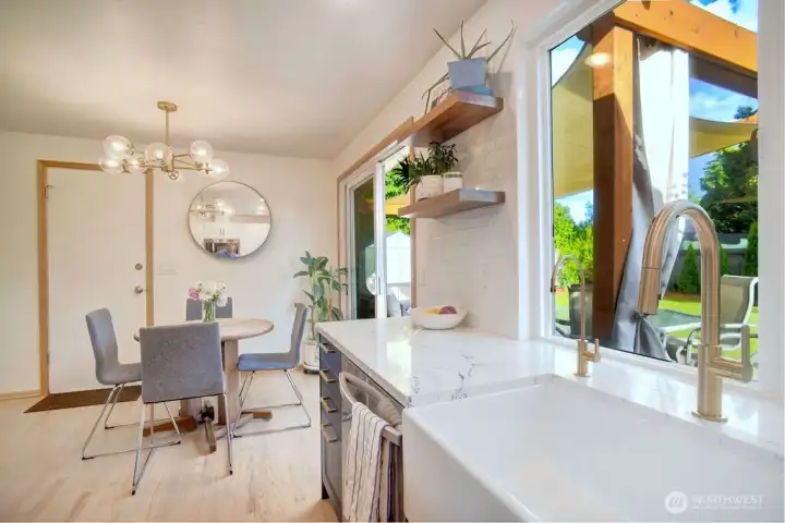 Designer light fixtures and sliding glass door leads to the spacious and daylight filled backyard