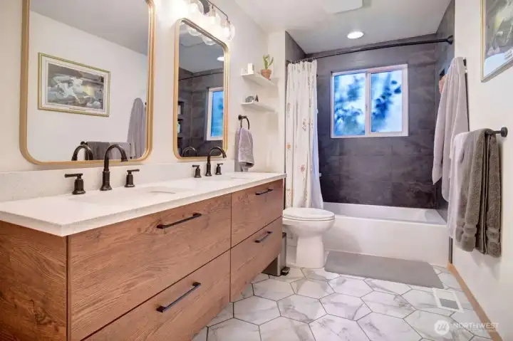 Floating bath vanity features double sinks with decorator mirrors and lighting. Don't miss the flooring and tile touches