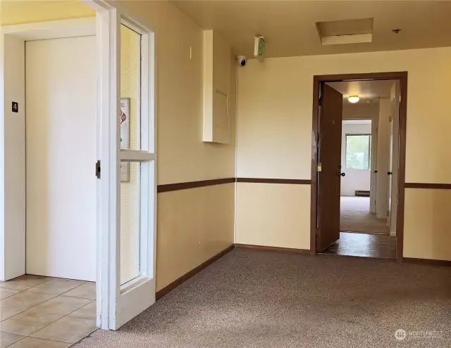 Entry door to the unit with peephole and security deadbolt lock. Near elevator for easy, quick access. No steps involved. Entry interior with Jeron®-brand communication intercom for visitor entry access. Faux-tile vinyl floor. Entry coat closet.