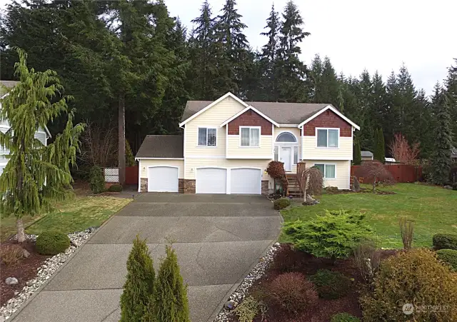 This is a front view of the house. The landscaping is professionally done, and there is plenty of parking in the driveway.