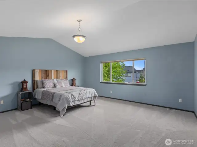 4th upstairs bedroom is the grand primary suite with vaulted ceilings & wide window!