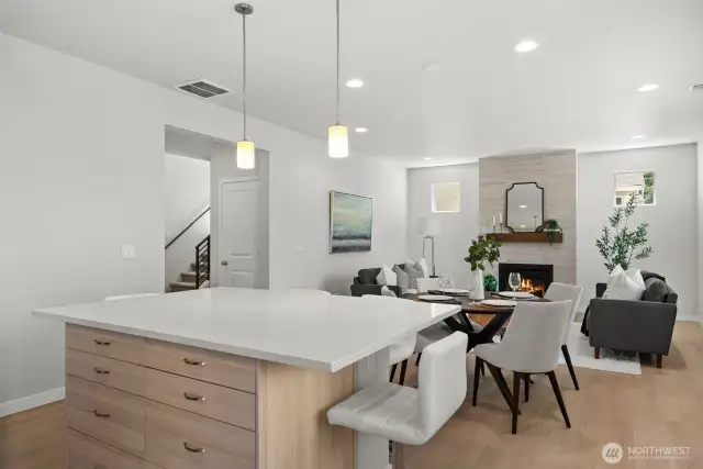 Upgraded wood-toned cabinetry beneath the island adds valuable storage while creating a seamless visual flow with the flooring for a stunning presentation.