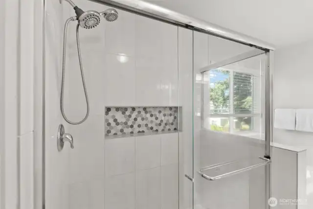 A decorative tiled inlaid shower shelf provides a place for shower essentials for a clutter free floor.