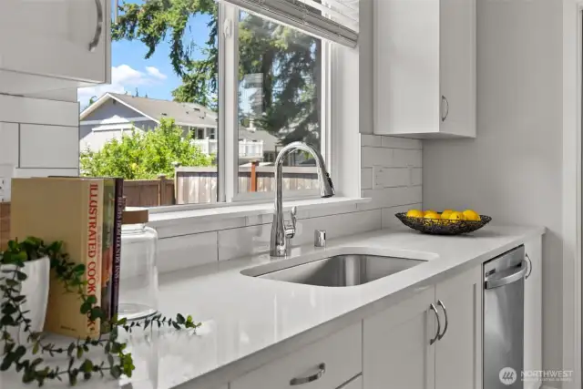 Look out to a fully fenced backyard while preparing a meal in this stunning kitchen space.