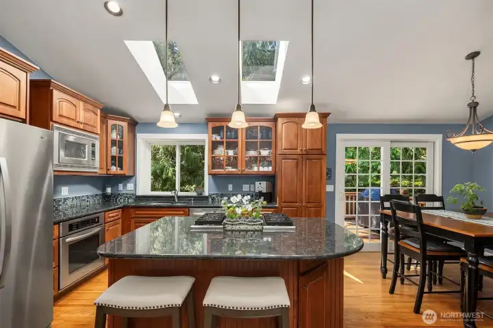 Well-appointed kitchen with stainless steel appliances, convenient eating bar, and skylights to let the brightness in.