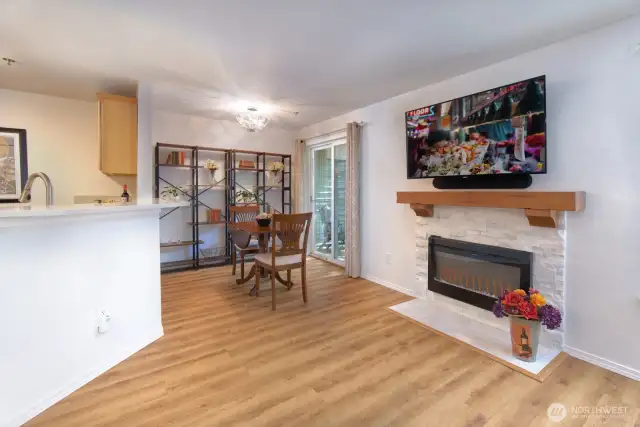 Dining room with newer LVP flooring, newer light fixture and bookcase can stay with the home.