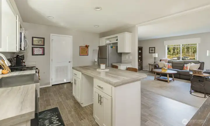 Enjoy white shaker cabinetry, a farmhouse-style sink, and open sightlines to the living area for effortless entertaining.