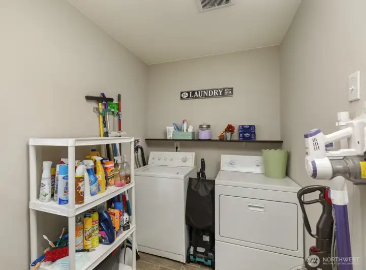 A separate laundry space with shelving and storage options keeps everyday chores organized and out of sight.