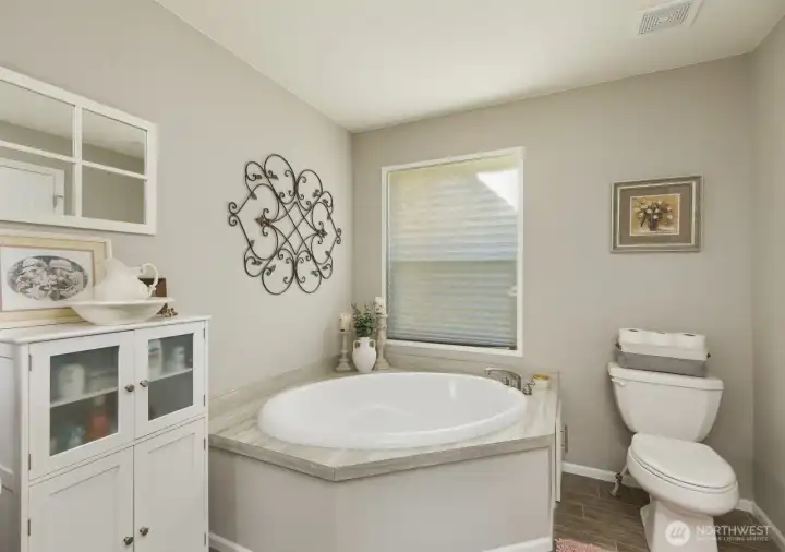 Featuring a large soaking tub, double vanity, and separate shower, this primary bathroom is designed for comfort and convenience.