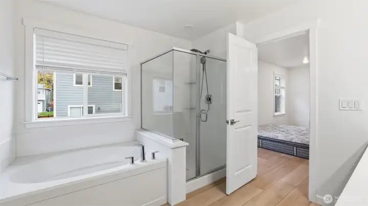 Enjoy the convenience of a glass-enclosed shower paired with a spacious soaking tub.