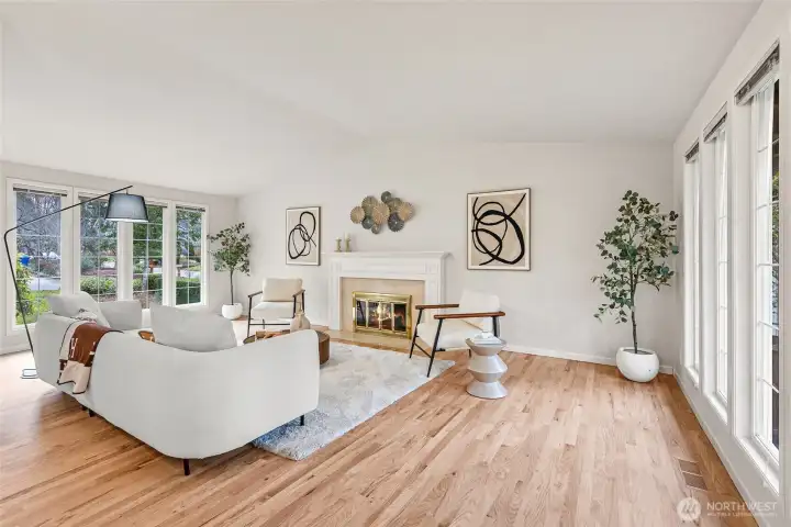 Spacious living room with over-sized windows and cozy wood-burning fireplace.