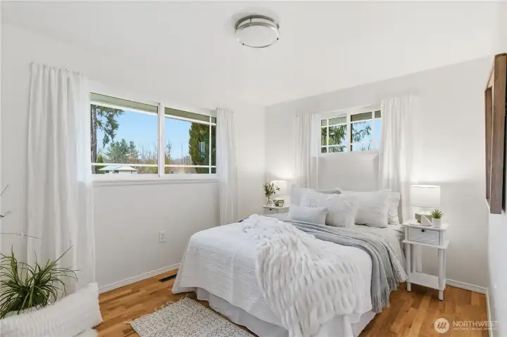 This spacious bedroom overlooks the backyard, with windows on two sides.