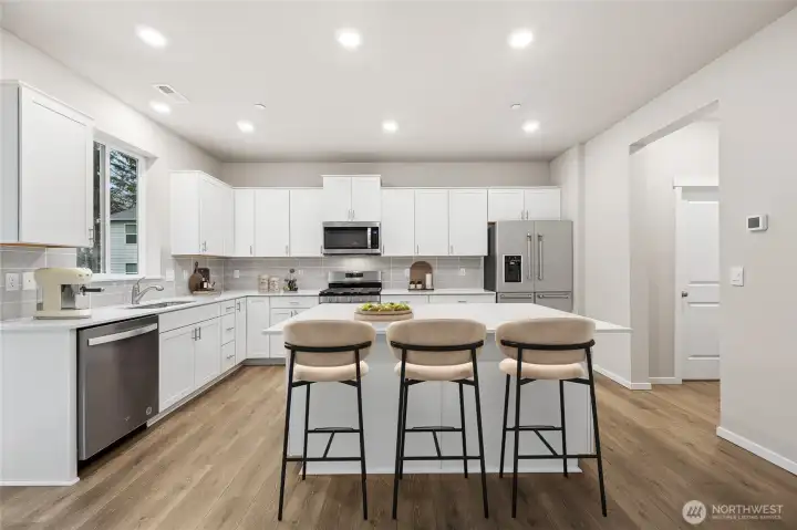 Island kitchen with stainless steel appliances and soft-close cabinetry. Picture for representational purposes only, colors and features may vary.