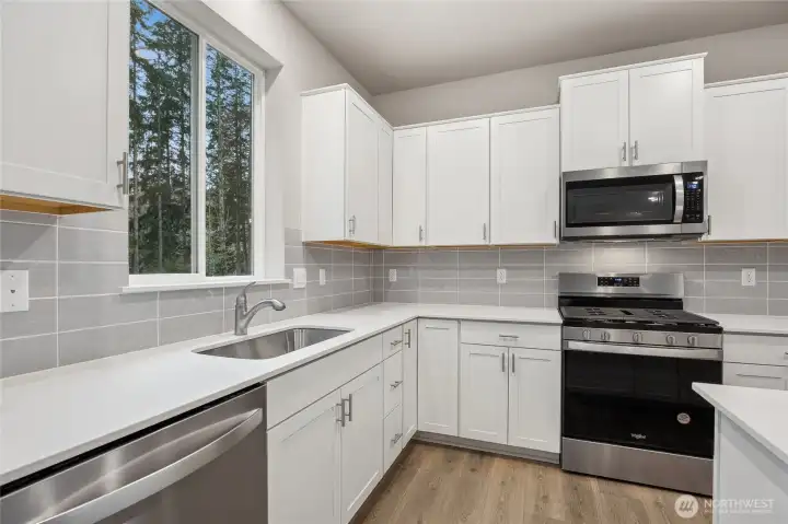 Gorgeous slab quartz countertops and full height tile backsplash. Picture for representational purposes only, colors and features may vary.