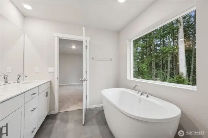 Soaking tub with a large picture window, perfect for relaxing after a long day. Picture for representational purposes only, colors and features may vary.
