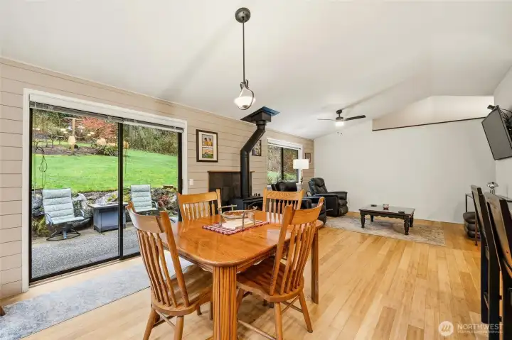 Dining area with bamboo flooring, large slider to the private backyard, and an A-frame living space that adds architectural character.
