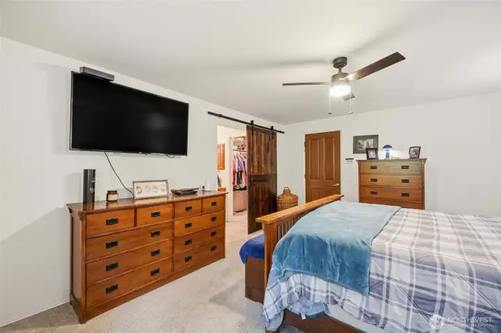 Primary suite with stylish barn doors leading to the bath and closet, adding character and a distinctive design touch.