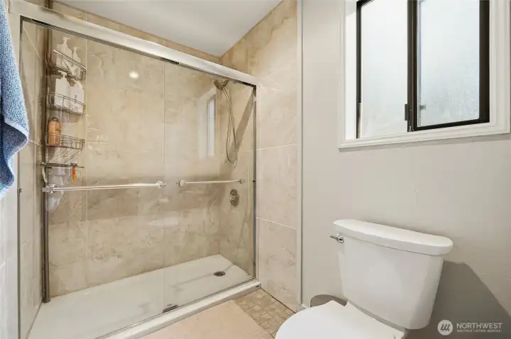 Walk-in tiled shower with clean finishes, adding comfort and style to the primary bath.