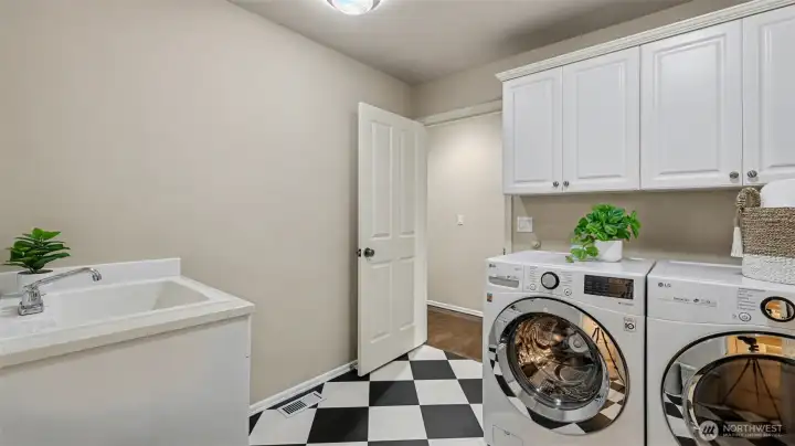 Utility room with built-in storage, sink, and fun vinyl flooring.
