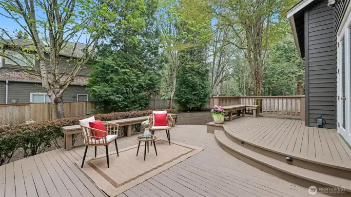 Tiered deck with built-in seating, illuminated stairs, and pergola.