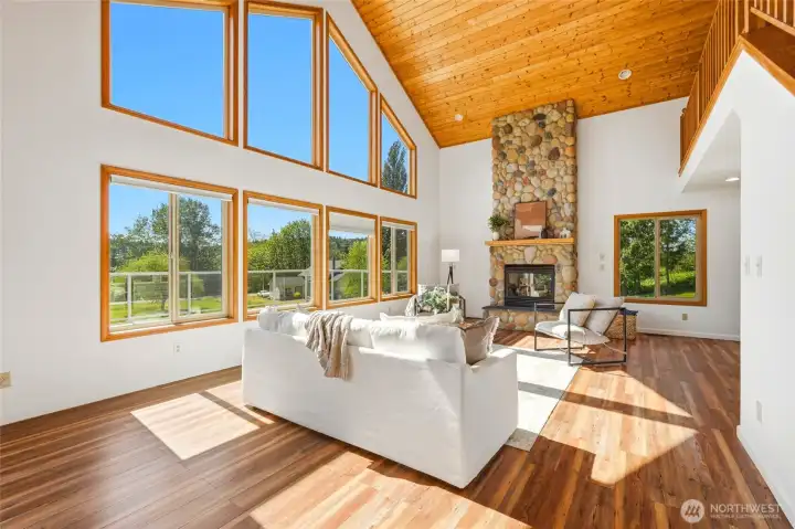 Soaring ceilings create instant wow the moment you enter.  Floor-to-ceiling rock fireplace anchors the entire living space beautifully.