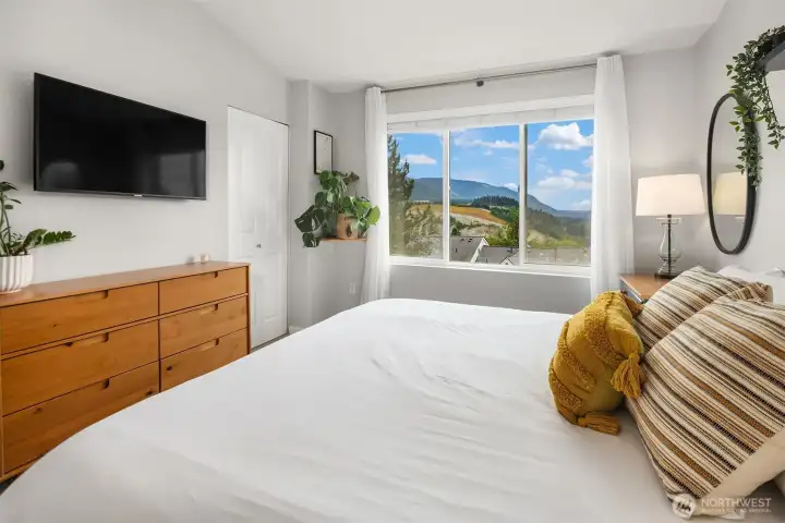 Primary suite with large windows bringing in ample natural light.