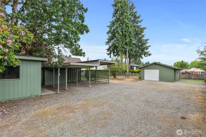 Large shed (on left) and two carports, garage with 200-amp service and half bath