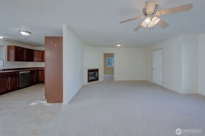 Living Rm. & Kitchen.  Door to primary next to fireplace & Laundry/Garage door to the right.