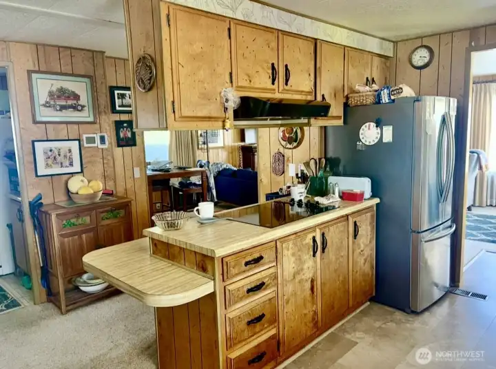 Kitchen with eating area, new fridge & stove top, dining room beyond