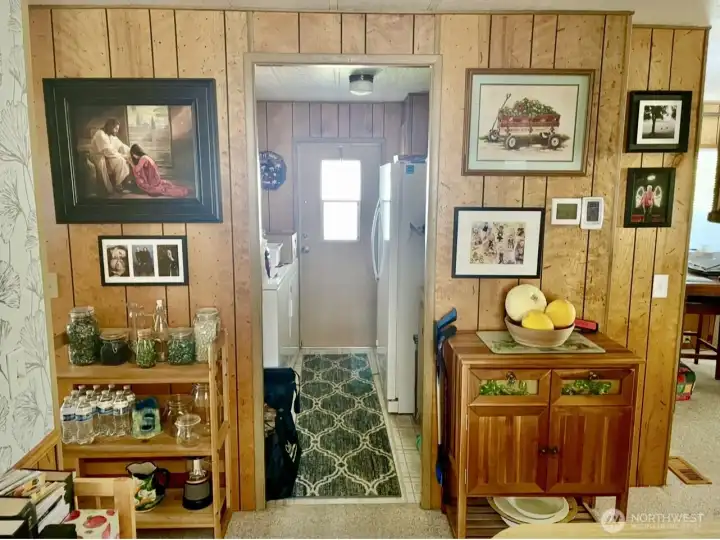 Looking into the utility room, door to carport, washer & dryer, sink, heatpump and storage