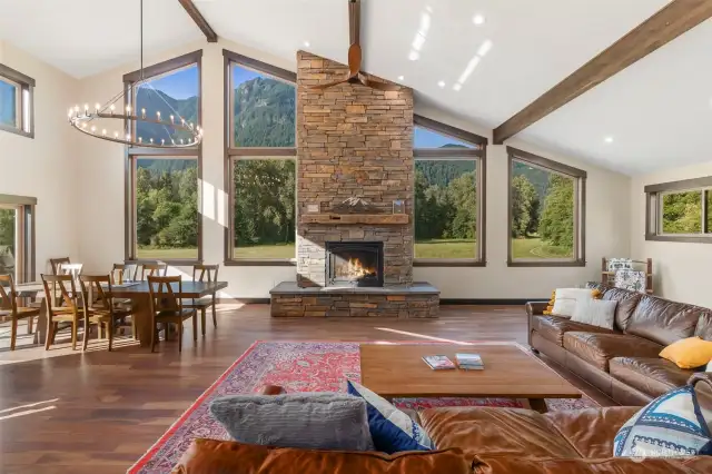 A striking double-sided stone fireplace anchors the great room, seamlessly connecting the living and dining areas. Rich hardwood floors throughout.