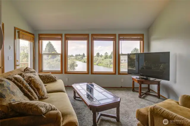 Inside the home, the living space capitalizes on the views looking up the canal, and the glass door on the left leads out to the deck.